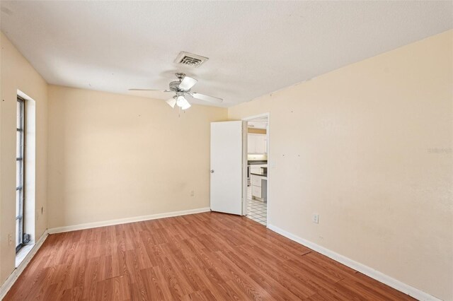 1301 Lucaya Ave, Venice, FL 34285 - empty room featuring wood finished floors, a ceiling fan, baseboards, and plenty of natural light