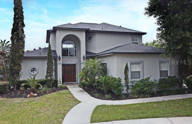 view of front of property featuring a front lawn and stucco siding
