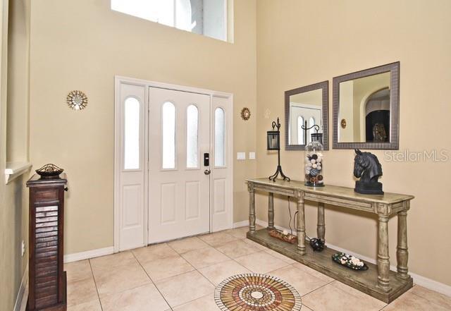 entrance foyer featuring a high ceiling, baseboards, and light tile patterned floors