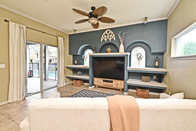 tiled living area featuring ceiling fan, crown molding, and baseboards