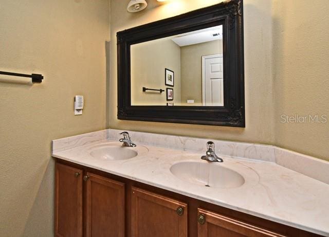 bathroom featuring double vanity and a textured wall