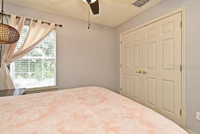 bedroom featuring ceiling fan and a closet