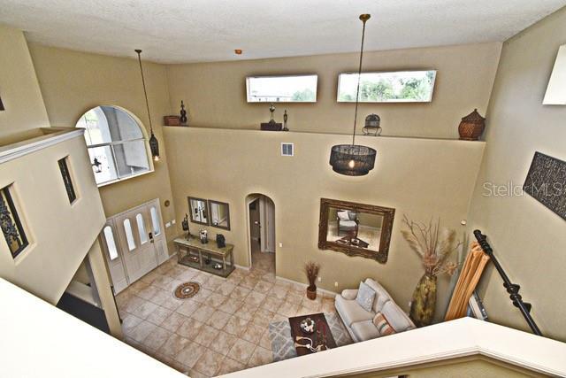 living area featuring arched walkways and tile patterned floors