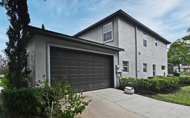 view of property exterior featuring stucco siding, driveway, and an attached garage