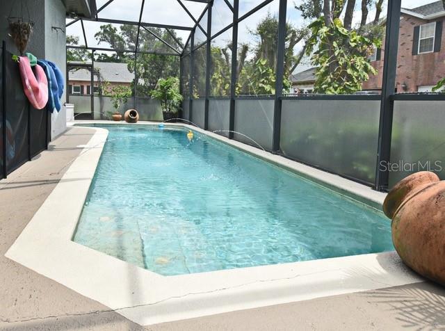 view of pool with glass enclosure