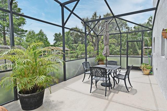 view of patio featuring glass enclosure and outdoor dining space