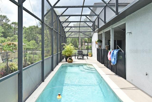 swimming pool featuring a lanai and a patio area