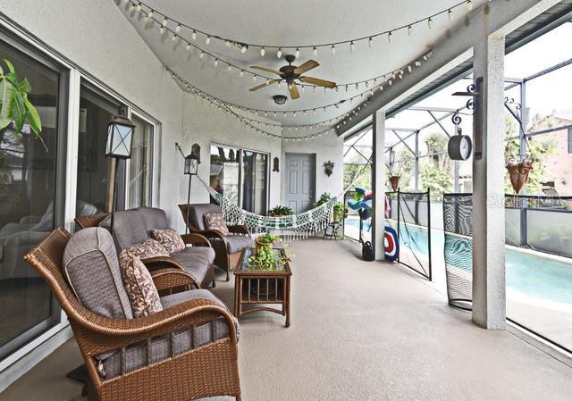 sunroom / solarium featuring ceiling fan and an outdoor living space