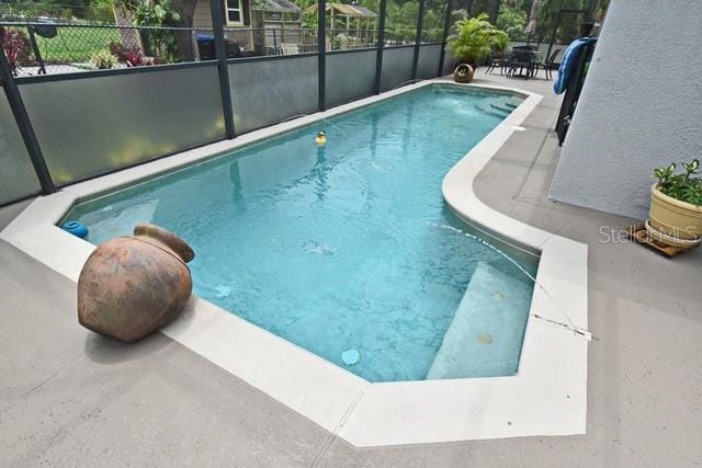 outdoor pool with a patio and fence