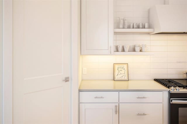 12536 Westhaven Oak Dr Unit 111, Winter Garden, FL 34787 - kitchen with stainless steel range with gas cooktop, backsplash, white cabinetry, light countertops, and open shelves