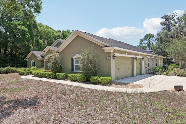 6686 SE 135th St, Summerfield, FL 34491 - view of side of home with stucco siding, concrete driveway, and an attached garage