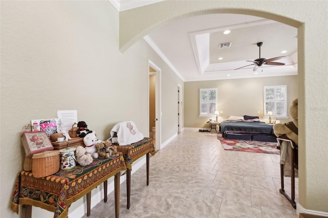 6686 SE 135th St, Summerfield, FL 34491 - bedroom featuring arched walkways, ornamental molding, a tray ceiling, baseboards, and ceiling fan