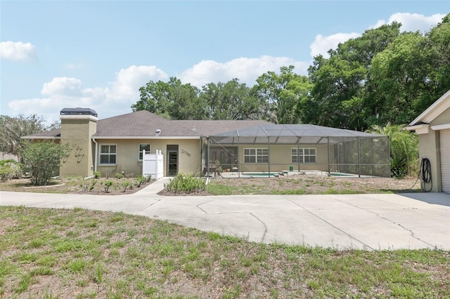 6686 SE 135th St, Summerfield, FL 34491 - ranch-style home with an outdoor pool, stucco siding, driveway, glass enclosure, and a patio