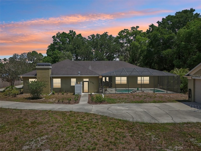 6686 SE 135th St, Summerfield, FL 34491 - ranch-style house with an outdoor pool, glass enclosure, a patio, stucco siding, and a yard