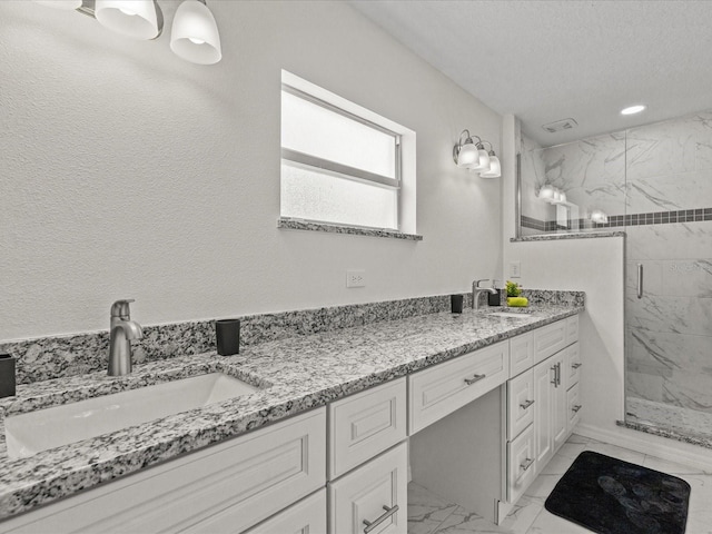 bathroom featuring marble finish flooring, a marble finish shower, and double vanity