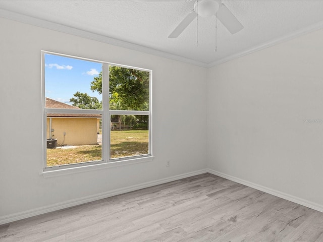 empty room featuring wood finished floors, ceiling fan, baseboards, and crown molding