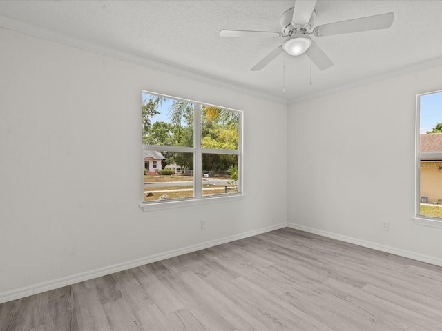 empty room featuring wood finished floors, crown molding, ceiling fan, and baseboards