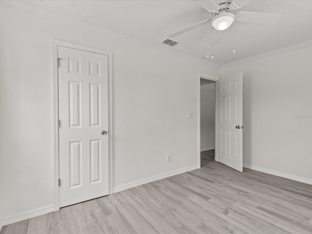unfurnished bedroom featuring ornamental molding, light wood-style flooring, baseboards, and ceiling fan