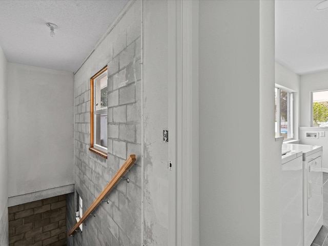 corridor with washer and clothes dryer and a textured ceiling