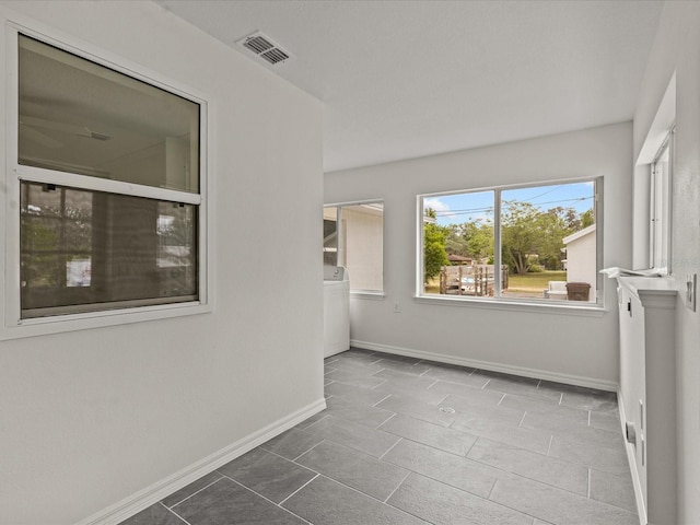 unfurnished room featuring washer / clothes dryer and baseboards