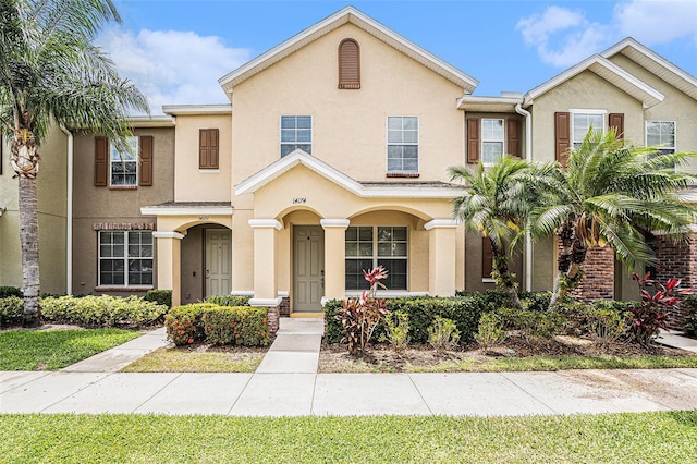 townhome / multi-family property featuring stucco siding and a porch