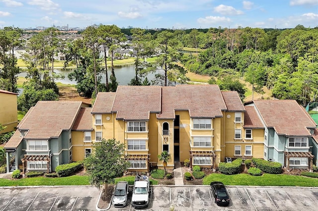 view of property with uncovered parking, a water view, and a residential view