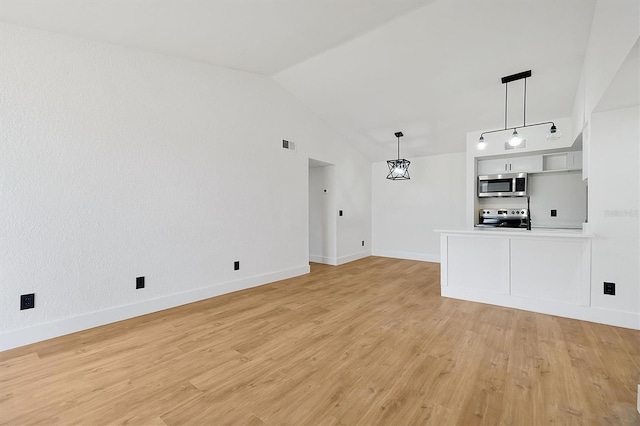 unfurnished living room with light wood finished floors, lofted ceiling, and baseboards