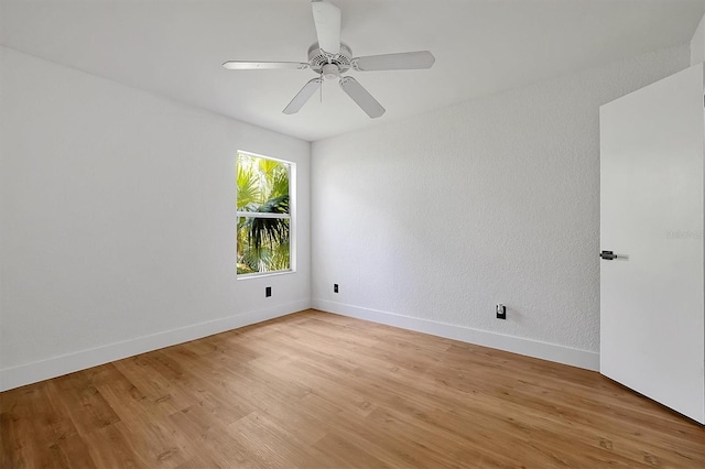 unfurnished room with light wood-style flooring, a ceiling fan, and baseboards