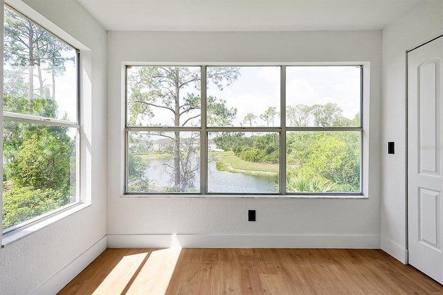 unfurnished sunroom with a water view