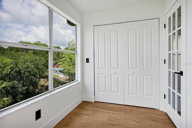 doorway featuring wood finished floors and baseboards