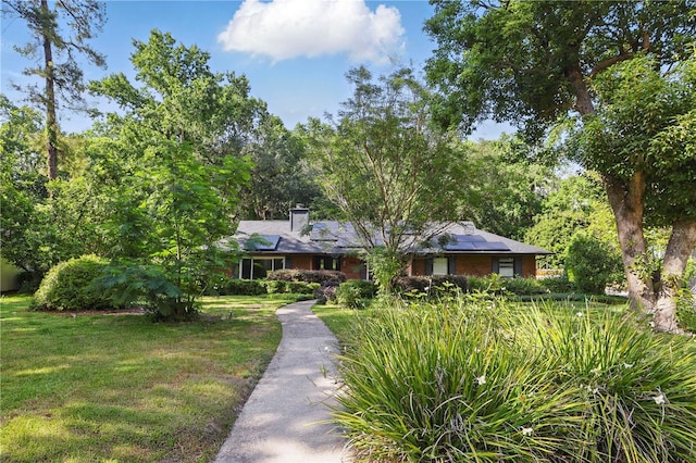 628 Riverpark Cir, Longwood, FL 32779 - single story home with solar panels, a front lawn, and a chimney