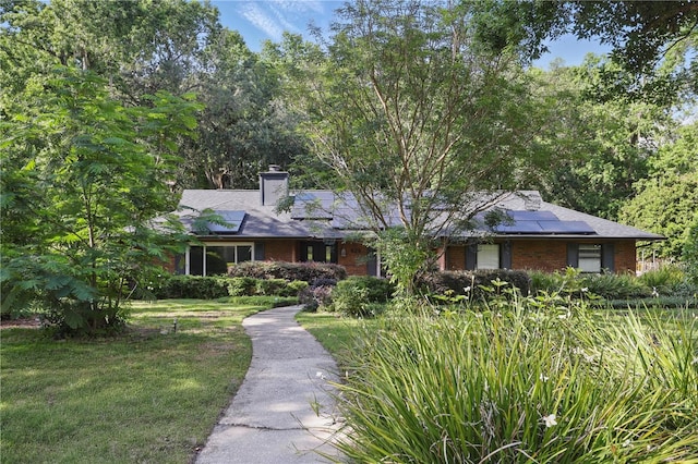 628 Riverpark Cir, Longwood, FL 32779 - ranch-style home featuring roof mounted solar panels, brick siding, a chimney, and a front lawn
