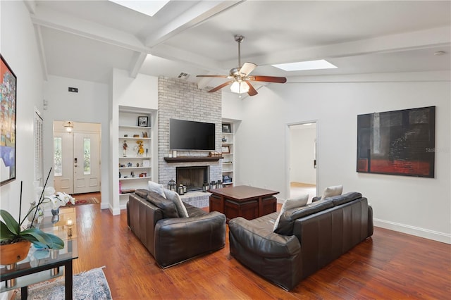 628 Riverpark Cir, Longwood, FL 32779 - living room featuring baseboards, a skylight, a ceiling fan, wood finished floors, and a brick fireplace