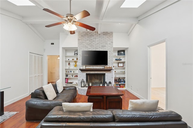 628 Riverpark Cir, Longwood, FL 32779 - living area featuring a brick fireplace, wood finished floors, ceiling fan, baseboards, and a skylight