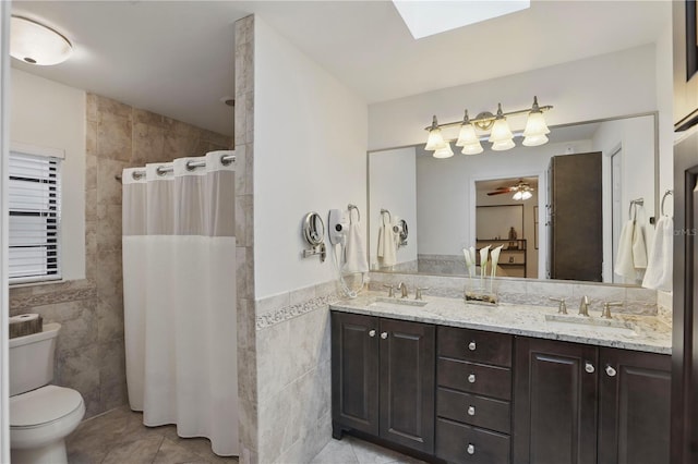 628 Riverpark Cir, Longwood, FL 32779 - bathroom featuring tile walls, tile patterned flooring, double vanity, tiled shower, and toilet