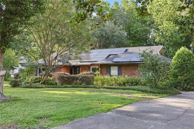 628 Riverpark Cir, Longwood, FL 32779 - single story home featuring a front lawn, brick siding, solar panels, and a shingled roof