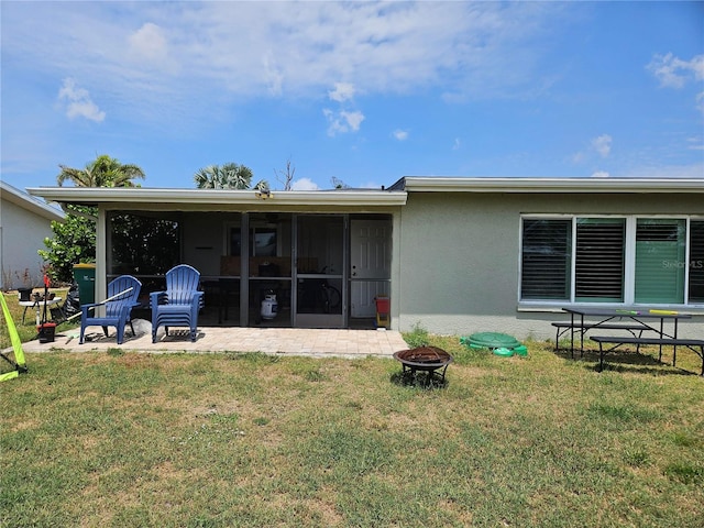 119 Caddy Rd, Rotonda West, FL 33947 - back of house featuring a fire pit, stucco siding, a yard, and a patio