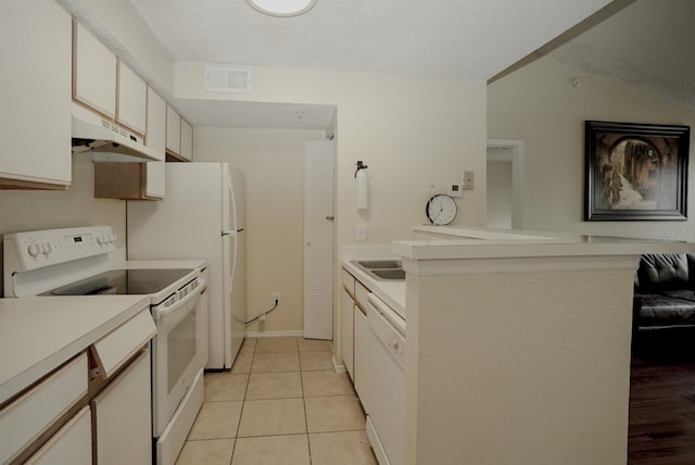 2208 Antigua Pl Unit 932, Kissimmee, FL 34741 - kitchen featuring under cabinet range hood, white appliances, light countertops, light tile patterned floors, and white cabinets
