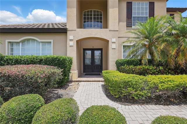 property entrance with french doors and stucco siding