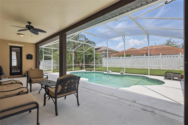 view of pool with a patio area, a fenced backyard, a ceiling fan, and a lanai