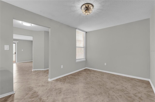 514 Orange Dr Unit 31, Altamonte Springs, FL 32701 - empty room with light tile patterned floors, a textured ceiling, and baseboards