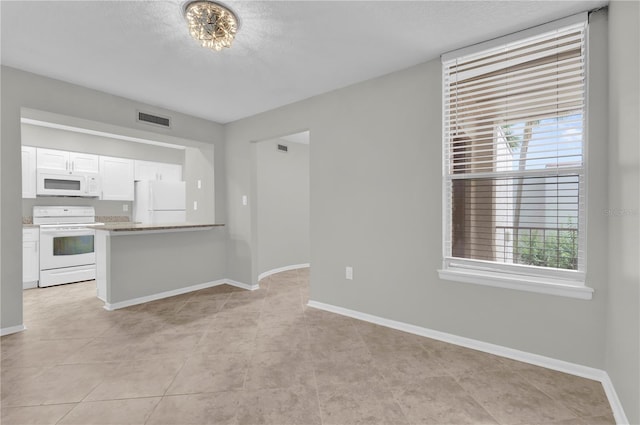 514 Orange Dr Unit 31, Altamonte Springs, FL 32701 - kitchen featuring white appliances, plenty of natural light, white cabinets, baseboards, and a textured ceiling