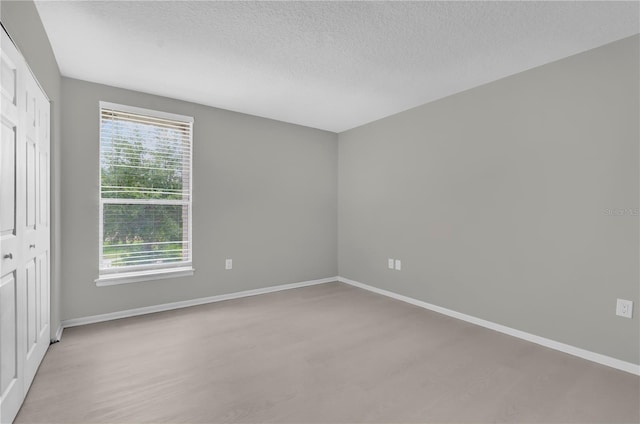 514 Orange Dr Unit 31, Altamonte Springs, FL 32701 - unfurnished bedroom featuring a textured ceiling, baseboards, a closet, and light wood-style flooring