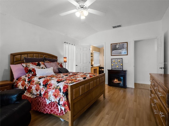 408 Becky St, Orlando, FL 32824 - bedroom featuring light wood-style floors, a warm lit fireplace, vaulted ceiling, baseboards, and ceiling fan