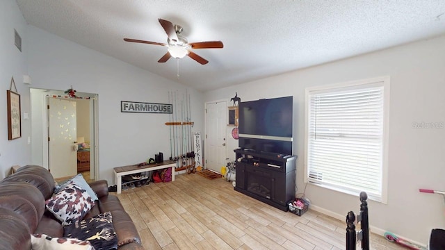 12381 Antonio Cir, Orlando, FL 32826 - living area with a ceiling fan, lofted ceiling, light wood-type flooring, a textured ceiling, and baseboards