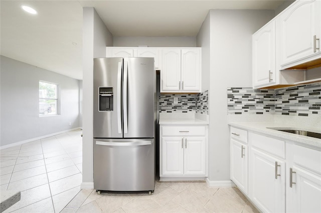 4824 Shoshone St, Orlando, FL 32819 - kitchen featuring stainless steel fridge with ice dispenser, tasteful backsplash, light tile patterned flooring, light countertops, and white cabinets