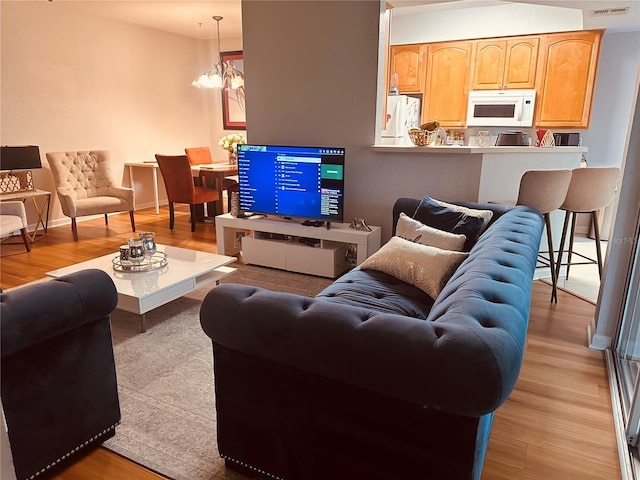 6450 Alcalde Ct Unit 106, Orlando, FL 32835 - living room with light wood-style flooring and a chandelier