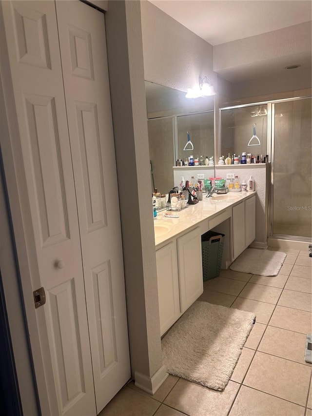 6450 Alcalde Ct Unit 106, Orlando, FL 32835 - bathroom with tile patterned floors, double vanity, a shower stall, and a closet