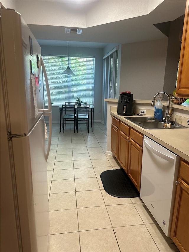 6450 Alcalde Ct Unit 106, Orlando, FL 32835 - kitchen with white appliances, light tile patterned flooring, brown cabinets, decorative light fixtures, and light countertops