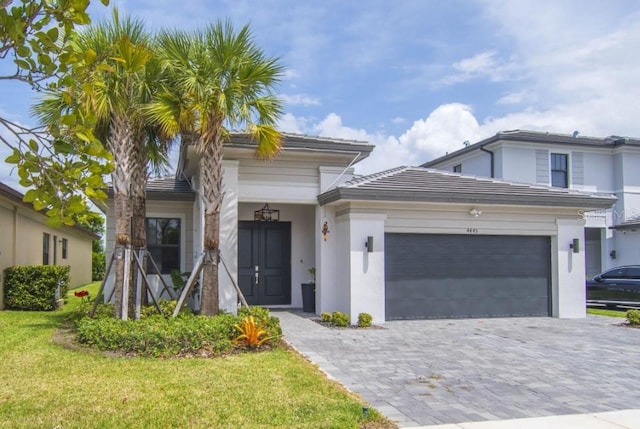 4445 SW 173rd Ave, Miramar, FL 33029 - view of front of home featuring a garage, stucco siding, decorative driveway, a front lawn, and a tile roof
